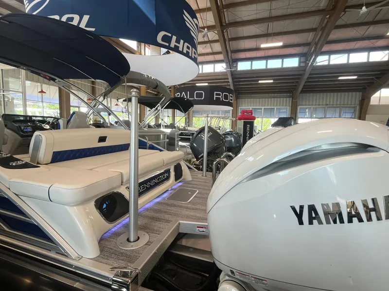 Slide: The Image of 2025 Bennington 27RSBWAT2 boat with Yamaha engine displayed in a showroom. - 19