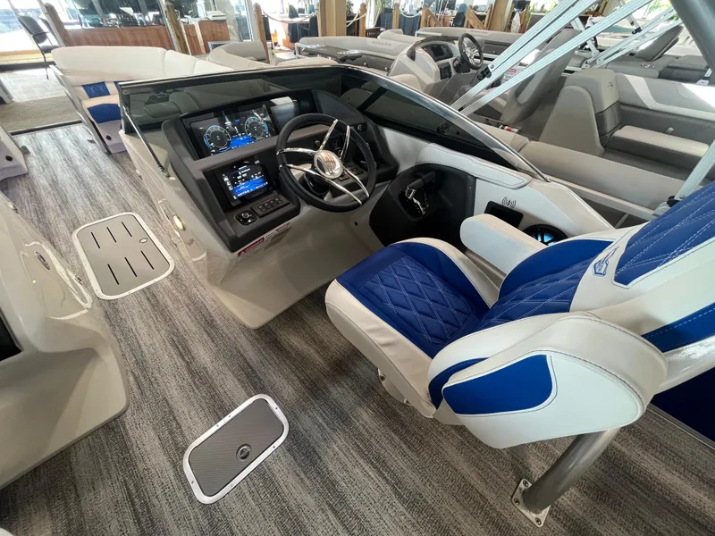 Slide: The Image of 2025 Bennington 27RSBWAT2 boat interior with modern dashboard and blue-accented captain's chair. - 6