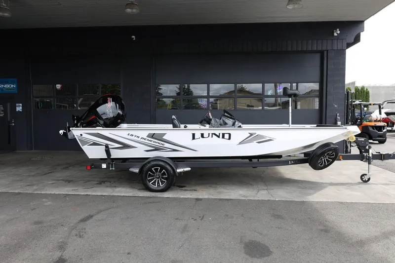 Slide: The Image of 2025 Lund 1875 Renegade SS boat on trailer, parked outside a building. - 1