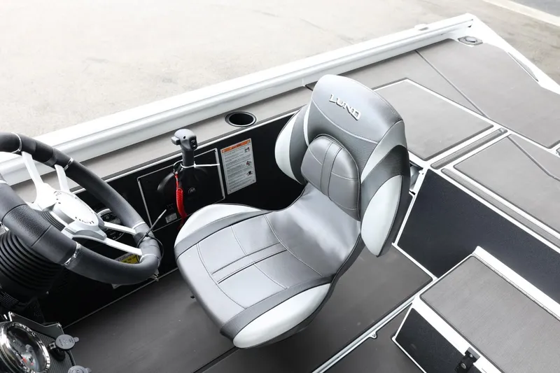 Slide: The Image of 2025 Lund 1875 Renegade SS boat interior with steering wheel and comfortable seating. - 20
