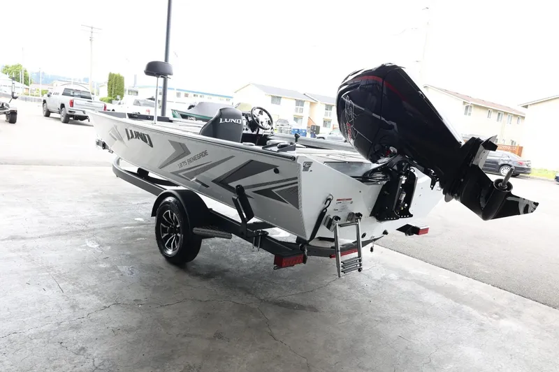Slide: The Image of 2025 Lund 1875 Renegade SS boat with outboard motor on trailer, parked outdoors. - 6