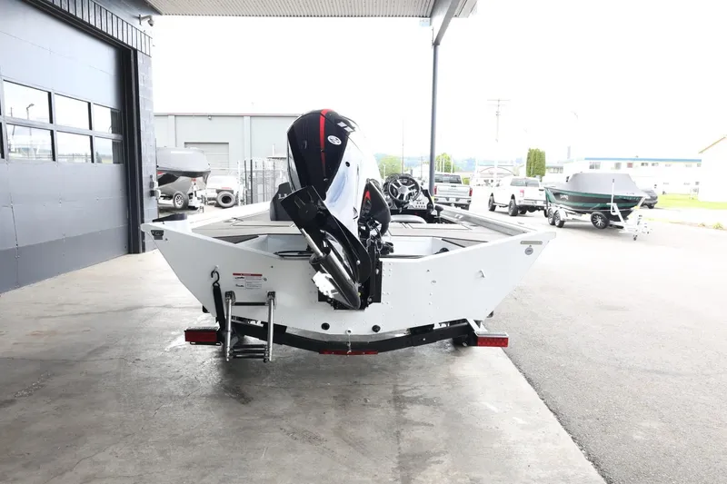 Slide: The Image of 2025 Lund 1875 Renegade SS boat in a showroom, rear view with motor. - 7