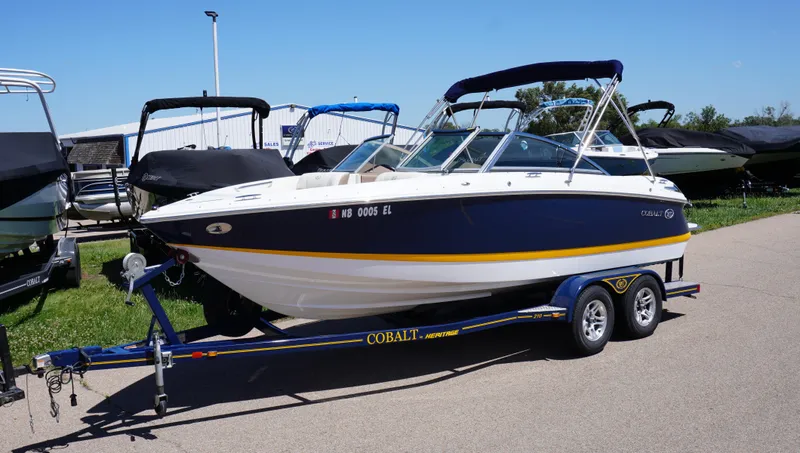 Slide: The Image of 2014 Cobalt 210 boat on trailer, parked outdoors, sunny day. - 1