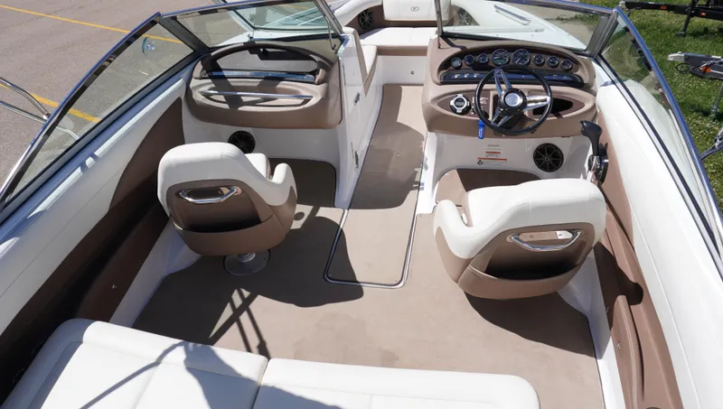 Slide: The Image of Interior of a 2014 Cobalt 210 boat, featuring beige and white seating and a sleek dashboard. - 10