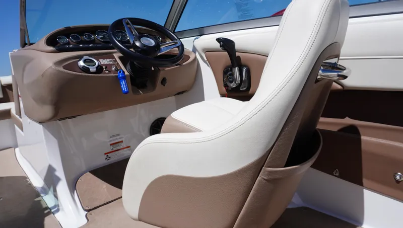 Slide: The Image of Interior of a 2014 Cobalt 210 boat, featuring steering wheel and captain's chair. - 21