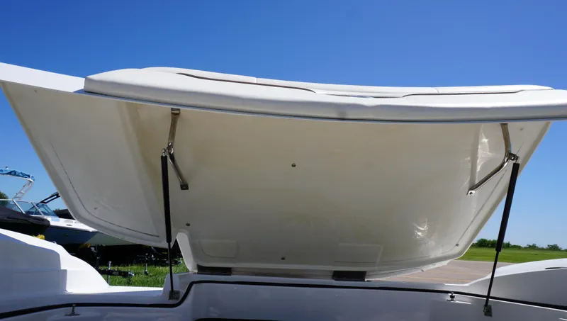 Slide: The Image of 2014 Cobalt 210 boat with open storage compartment under clear blue sky. - 24
