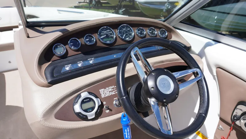Slide: The Image of Steering wheel and dashboard of a 2014 Cobalt 210 boat, featuring multiple gauges. - 26