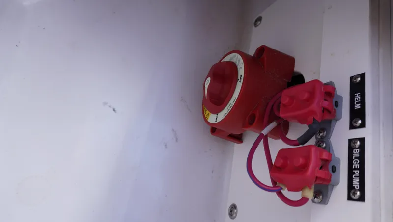 Slide: The Image of Red switch panel in a 2014 Cobalt 210 boat, labeled for helm and bilge pump. - 30