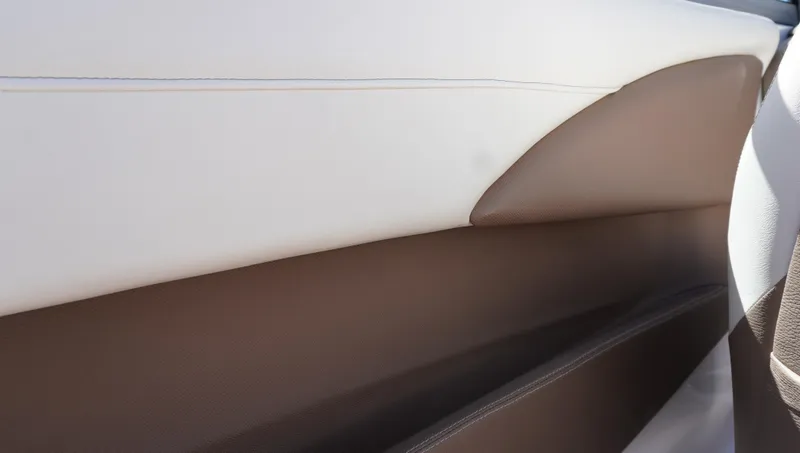 Slide: The Image of Interior detail of a 2014 Cobalt 210 boat, featuring brown and white upholstery. - 36