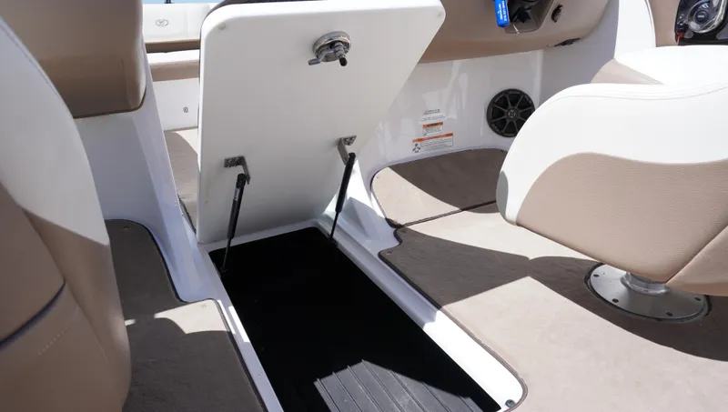 Slide: The Image of 2014 Cobalt 210 boat interior with open storage compartment and beige seating. - 41