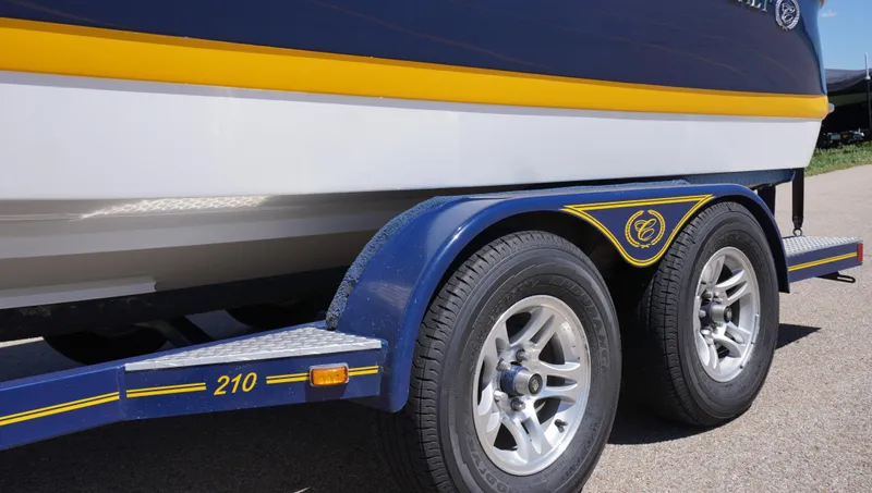 Slide: The Image of 2014 Cobalt 210 boat on trailer, featuring blue and yellow accents with dual wheels. - 5