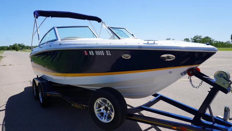 Slide: The Image of 2014 Cobalt 210 boat on trailer, parked outdoors under clear sky. - 7
