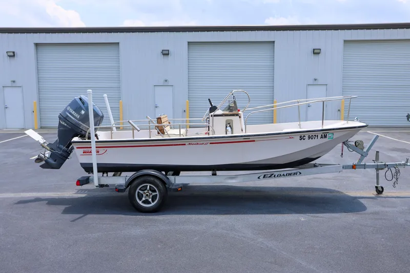 Slide: The Image of 1995 Boston Whaler 17 Montauk boat on trailer, parked outside storage facility. - 0