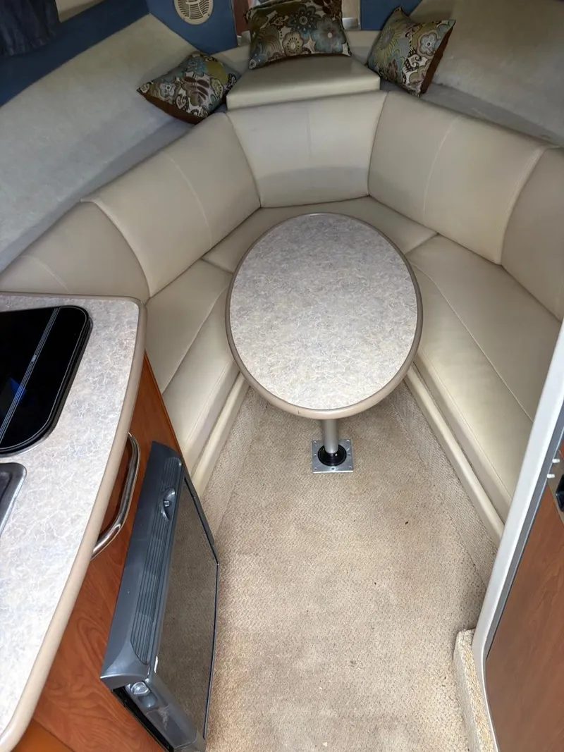 Slide: The Image of 2007 Bayliner 245 Cruiser interior with beige seating and table. - 10