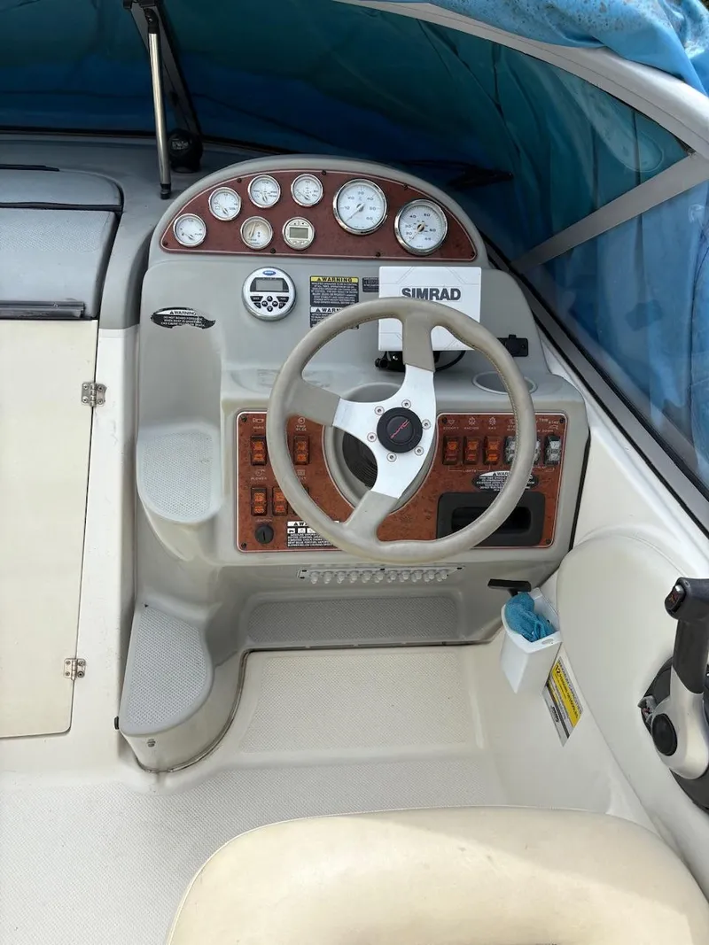 Slide: The Image of 2007 Bayliner 245 Cruiser helm with steering wheel, gauges, and Simrad navigation system. - 16