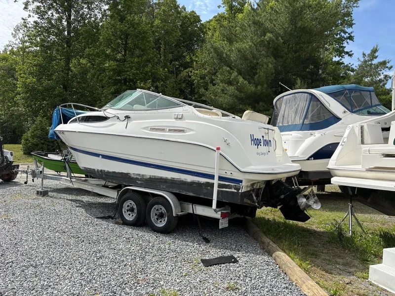 Slide: The Image of 2007 Bayliner 245 Cruiser on trailer, parked outdoors near trees. - 4