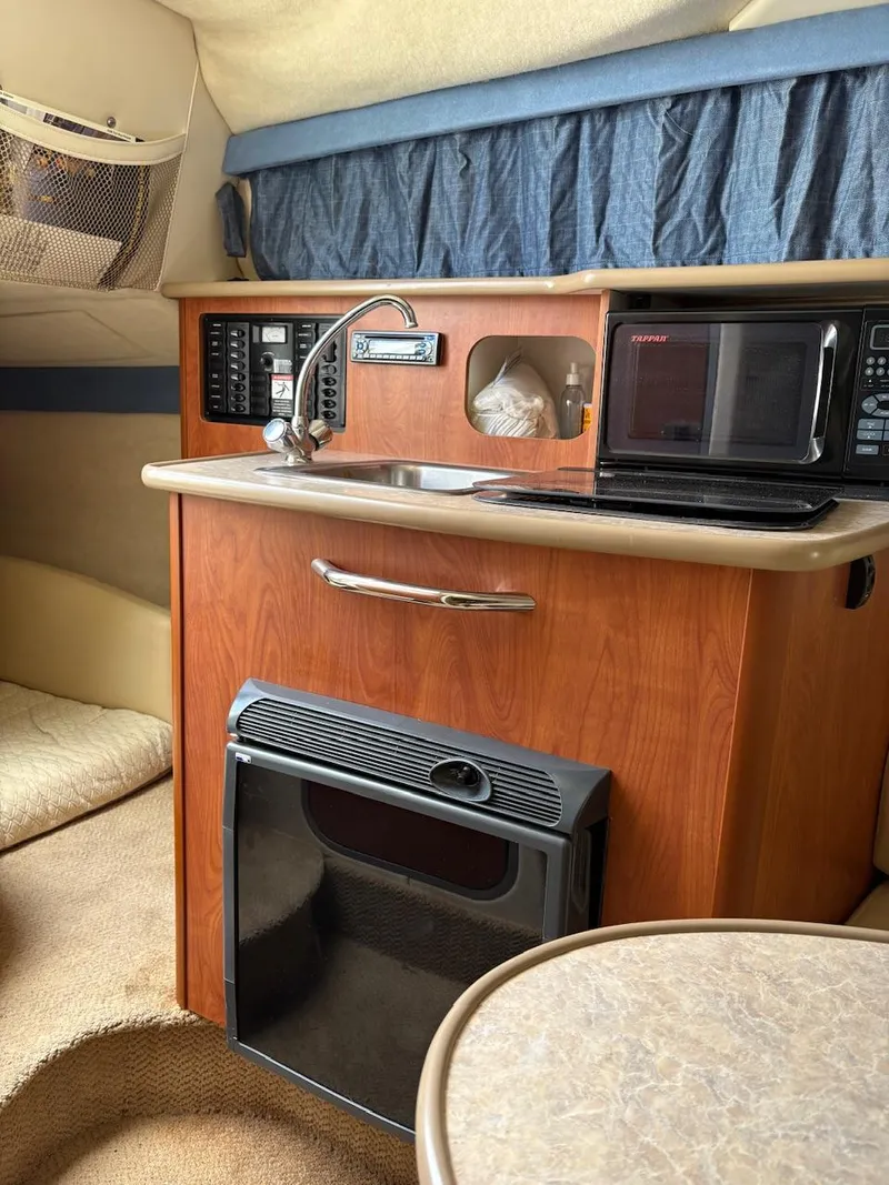Slide: The Image of 2007 Bayliner 245 Cruiser interior with kitchenette, microwave, and sink. - 8