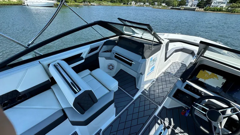 Slide: The Image of 2024 Cobalt R4 Outboard boat interior with modern seating and dashboard, on a scenic waterway. - 10