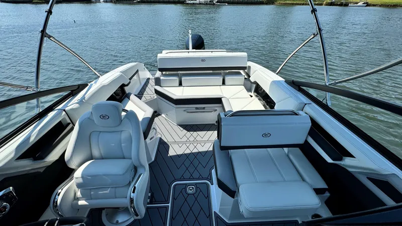 Slide: The Image of 2024 Cobalt R4 Outboard boat interior with luxurious white seating on a calm lake. - 14