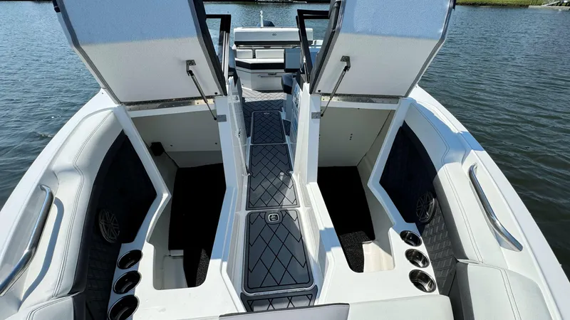 Slide: The Image of 2024 Cobalt R4 Outboard boat interior with open storage compartments on a calm lake. - 17