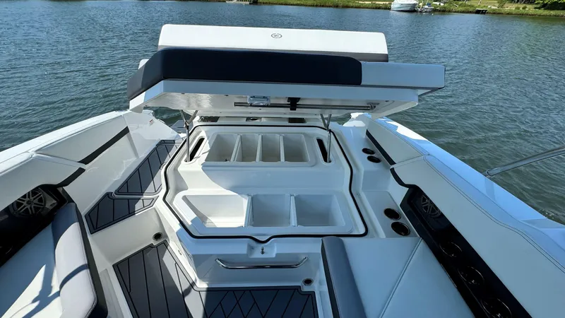 Slide: The Image of 2024 Cobalt R4 Outboard boat with open storage compartments on a calm lake. - 19
