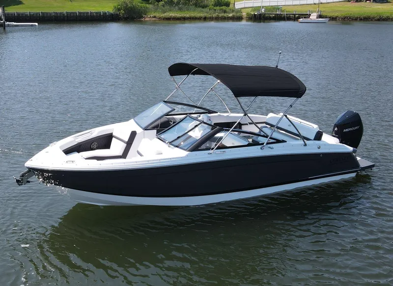 Slide: The Image of 2024 Cobalt R4 Outboard boat on calm water, featuring sleek design and black canopy. - 2