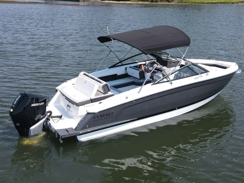 Slide: The Image of 2024 Cobalt R4 Outboard boat with black canopy cruising on a calm lake. - 3