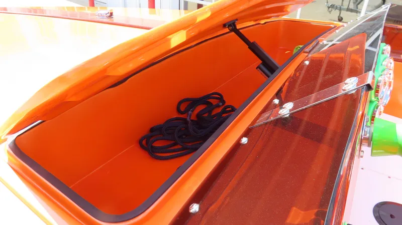 Slide: The Image of Open storage compartment in a 1979 Cigarette 20 boat, featuring an orange interior and black rope. - 10