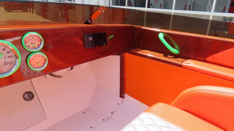Slide: The Image of 1979 Cigarette 20 boat interior with orange and wood accents, featuring gauges and seating. - 14