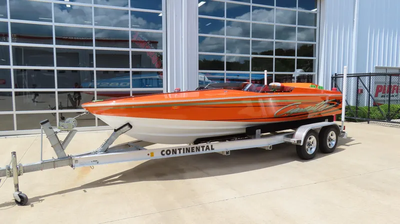 Slide: The Image of 1979 Cigarette 20 speedboat in orange on a Continental trailer, parked outside a garage. - 18