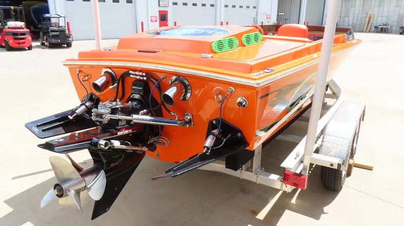 Slide: The Image of 1979 Cigarette 20 boat, orange, on trailer, rear view showing dual propellers and engine. - 2