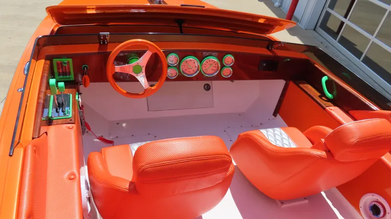 Slide: The Image of 1979 Cigarette 20 boat interior with vibrant orange seats and dashboard, featuring classic gauges and controls. - 3
