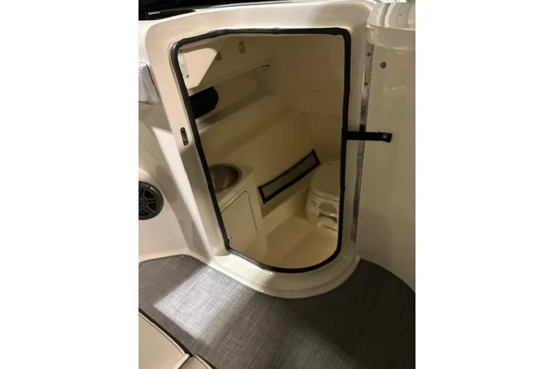 Slide: The Image of 2016 Sea Ray 270 Sundeck interior cabin with toilet and storage space. - 15