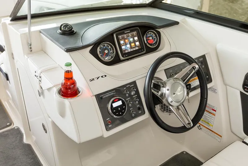 Slide: The Image of 2016 Sea Ray 270 Sundeck boat docked on calm water, featuring spacious seating. - 9