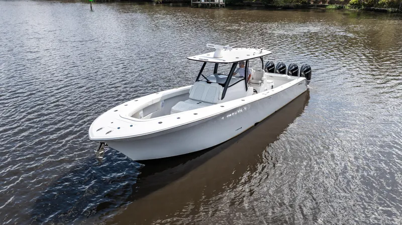 Slide: The Image of 2023 Front Runner 39 Center Console boat on calm water, featuring sleek design and multiple engines. - 14