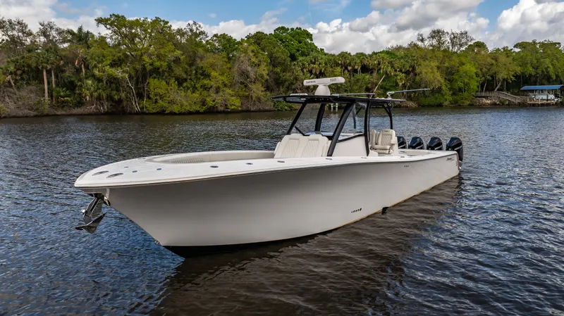 Slide: The Image of 2023 Front Runner 39 Center Console boat on a serene river with lush greenery. - 6