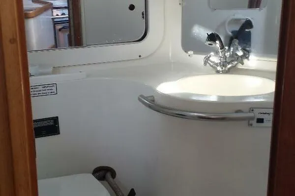 Slide: The Image of Bathroom interior of a 1994 Catalina 320 yacht, featuring a sink and mirror. - 15