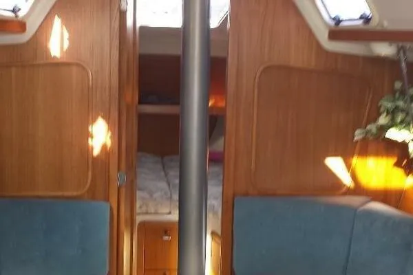 Slide: The Image of Interior of a 1994 Catalina 320 sailboat with wood paneling and blue seating. - 7
