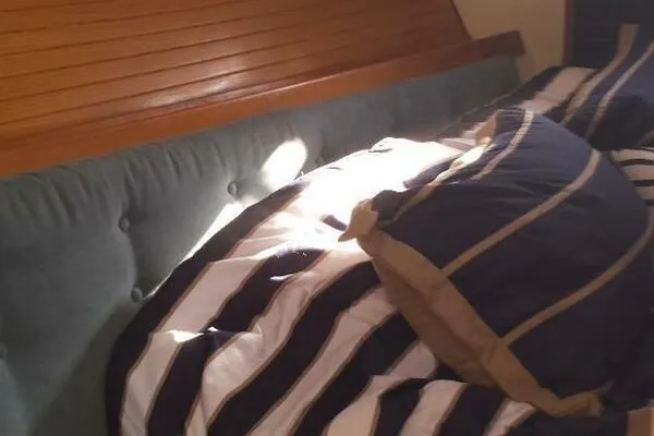 Slide: The Image of Cozy cabin bed with striped bedding in a 1994 Catalina 320 sailboat. - 6