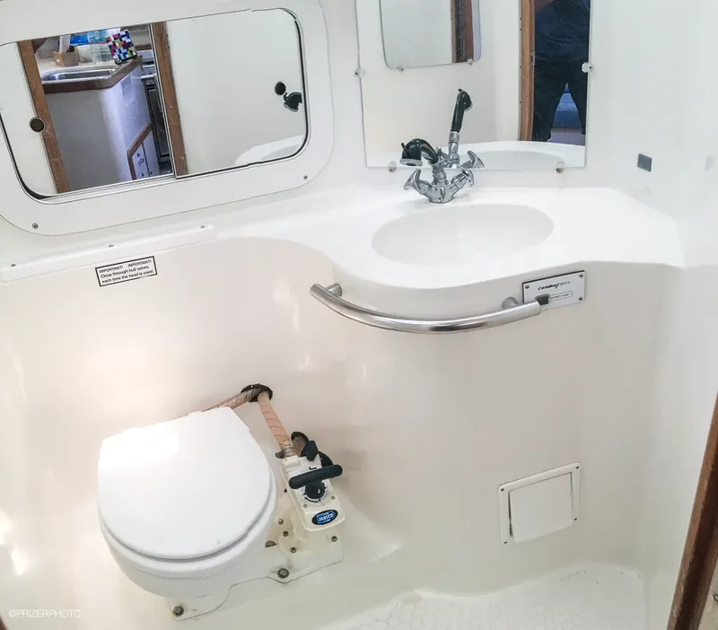 Slide: The Image of 1994 Catalina 320 yacht bathroom with toilet, sink, and mirror. - 12