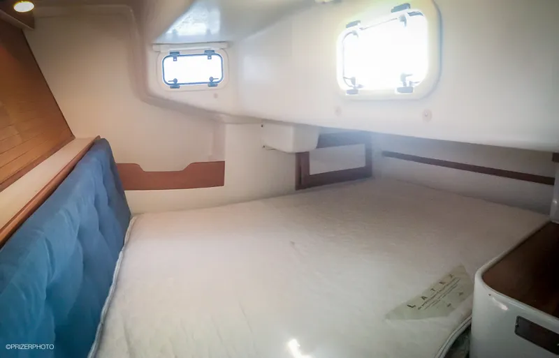 Slide: The Image of Cozy cabin interior of 1994 Catalina 320 sailboat with bed and porthole window. - 11
