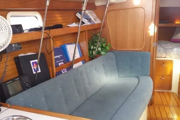 Slide: The Image of Interior of 1994 Catalina 320 sailboat with blue sofa and wooden accents. - 14