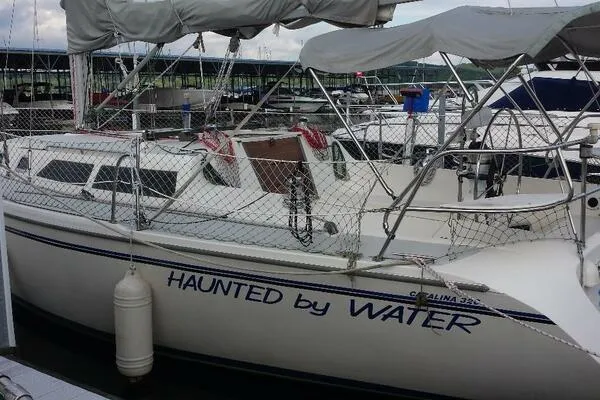 Slide: The Image of 1994 Catalina 320 sailboat named "Haunted by Water" docked at a marina. - 4