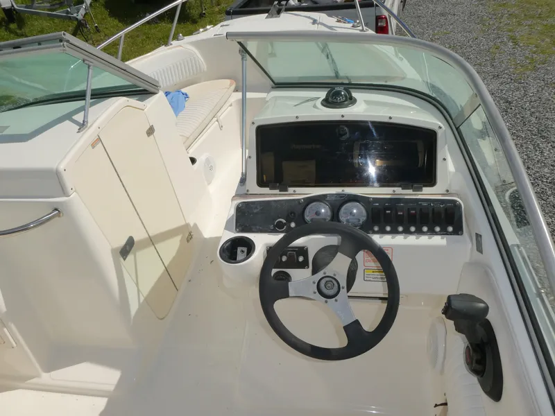 Slide: The Image of 2005 Boston Whaler 210 Ventura boat cockpit with steering wheel and dashboard controls. - 11