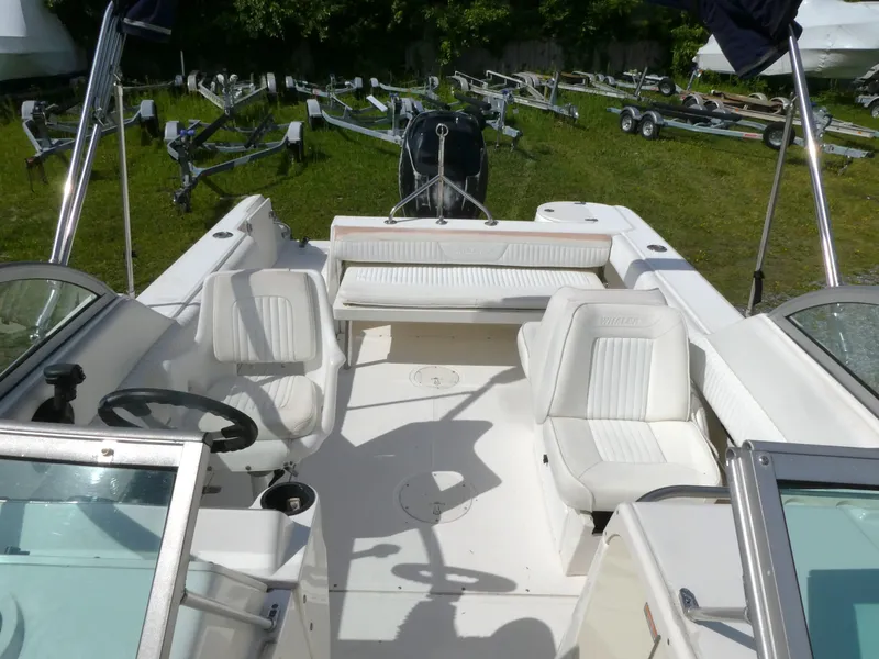 Slide: The Image of 2005 Boston Whaler 210 Ventura boat interior with white seating and steering wheel. - 15