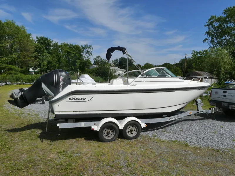Slide: The Image of 2005 Boston Whaler 210 Ventura boat on trailer, parked outdoors on gravel. - 3