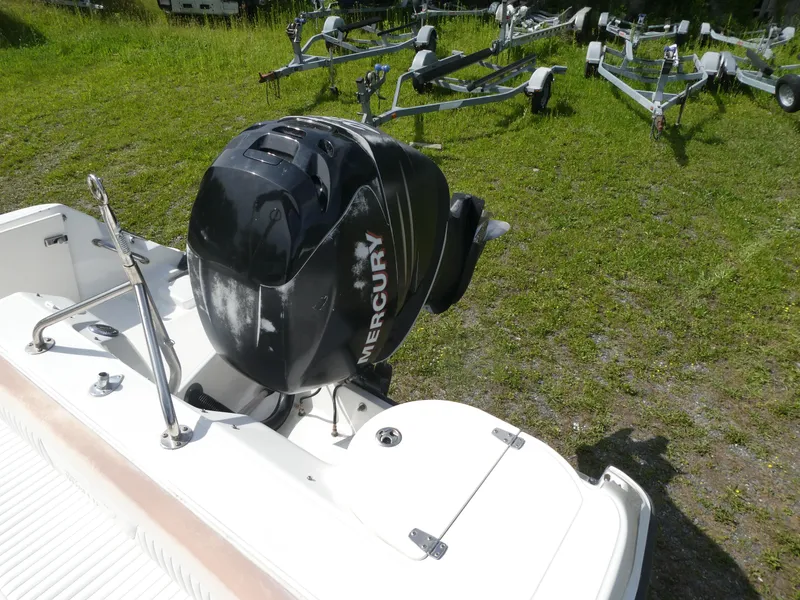 Slide: The Image of 2005 Boston Whaler 210 Ventura boat with Mercury outboard motor on grassy area. - 5