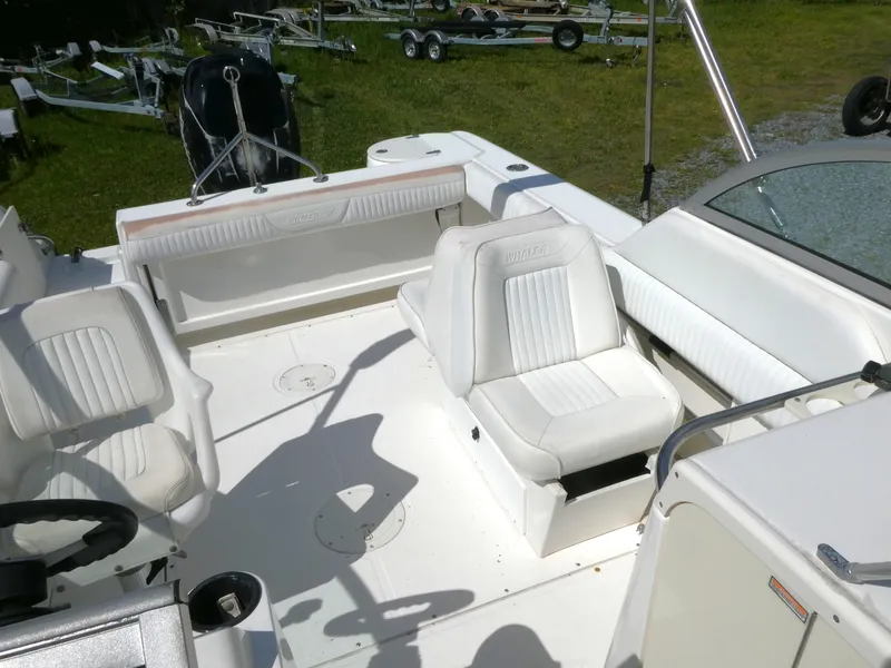 Slide: The Image of 2005 Boston Whaler 210 Ventura boat interior with white seating and steering wheel. - 7