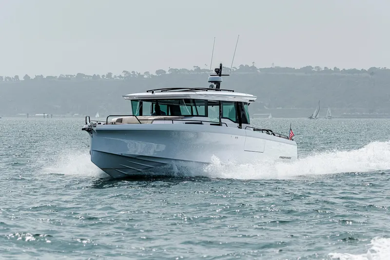 Slide: The Image of 2023 Axopar 45 Cross Cabin boat cruising on open water. - 2
