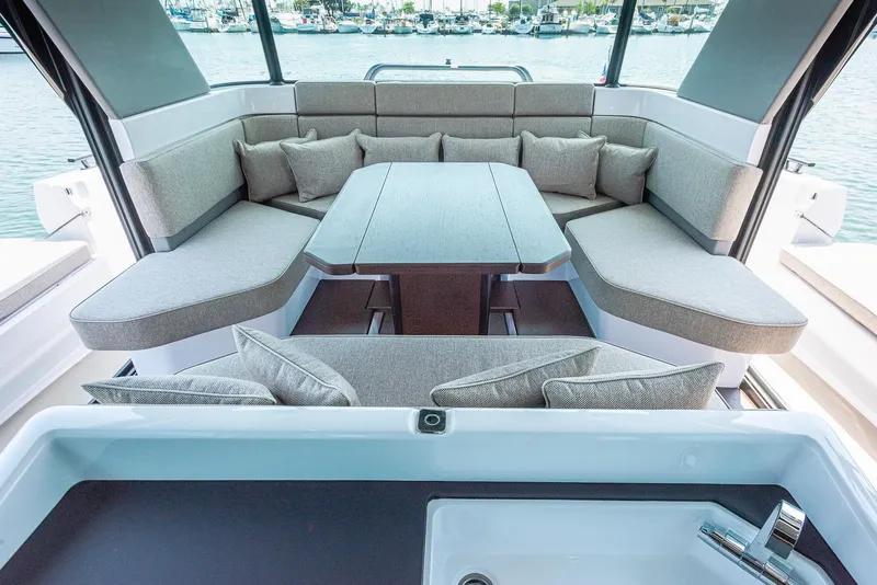Slide: The Image of Luxurious seating area on 2023 Axopar 45 Cross Cabin boat with elegant cushions and table. - 21